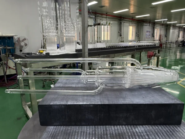 Hydrogen-oxygen torch processing high-purity quartz glass tube in a cleanroom environment for semiconductor manufacturing applications.